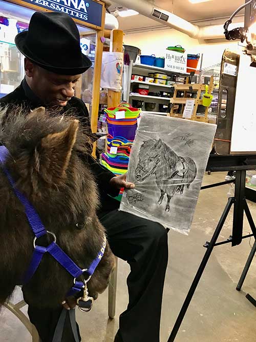 Dominique admiring a drawing of himself.